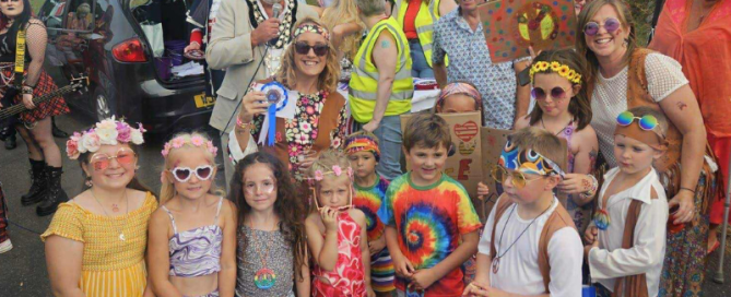 Image of the Mayor at Ilfracombe Carnival surrounded by young children in fancy dress and face paintings.